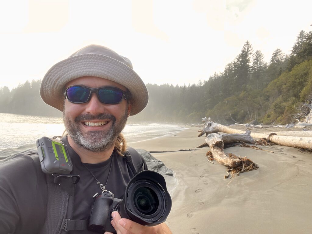 2021, Selfie Person standing on a beach with a camera.